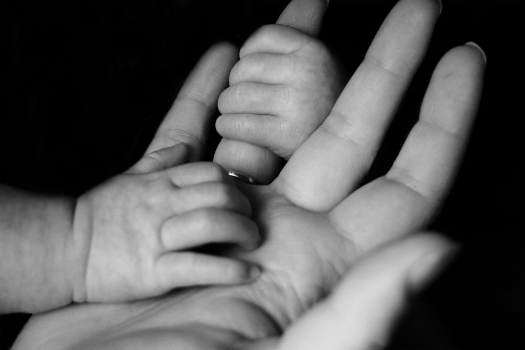 une main tenant la main de son enfant